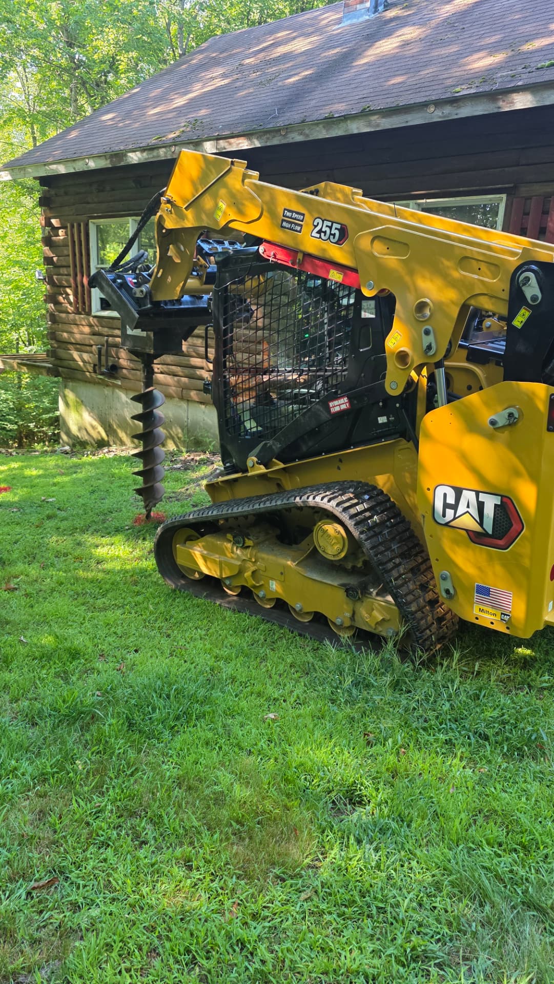 CAT 255 compact track loader with auger attachment at a job site